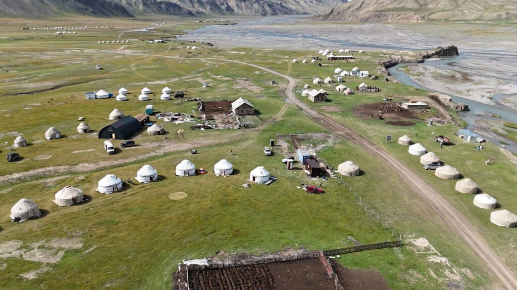 Панорамна гледка от високо към юртен лагер и долина в Киргизстан